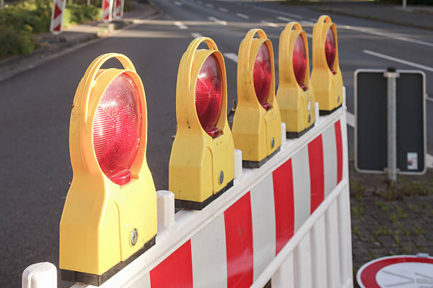 istock Red warning lights flashing on road construction barrier 2234112121