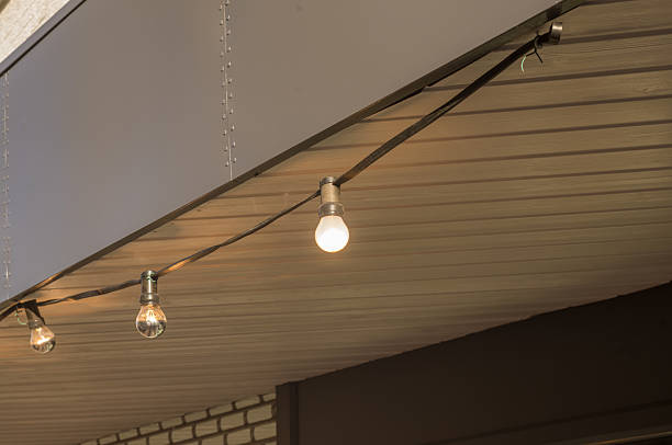 String of outdoor light bulbs illuminating a wooden porch ceiling