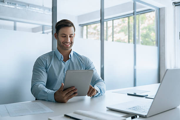 istock European man using tablet for communication, reading, browsing internet, checking banking trade news. Young businessman working online, studying on touchscreen device at office workplace. Copy space 2234112759