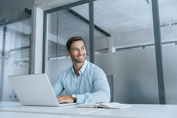 istock Portrait of Latin hispanic business man ceo trader using laptop computer, typing, working in office. Young European smiling handsome businessman entrepreneur looking aside at copy space, dreaming 2234112778