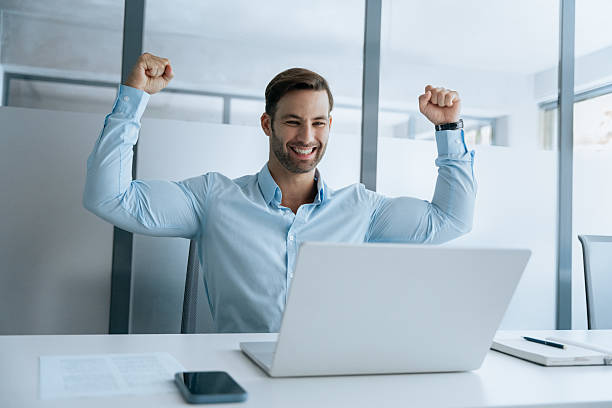 istock Happy excited young latin hispanic student businessman looking at laptop pc computer does yes win gesture. Smiling European business man successful winner celebrating victory winning achieve in office 2234112793