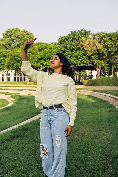 istock Young Woman Taking a Photo in a Scenic Park Setting 2234113804