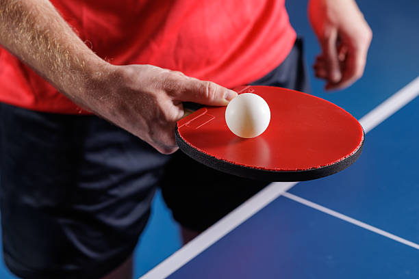 istock Table tennis serve preparation with red paddle and ball over blue table closeup 2234114059
