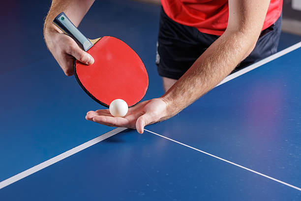 istock Table tennis serve closeup with red paddle and ball over blue table 2234114062