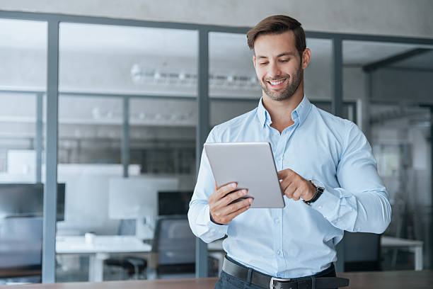 istock European smiling young businessman entrepreneur working on touchscreen computer device. Latin hispanic ceo business man ceo manager using tablet pad computer in office, looking at screen. Copy space 2234118489