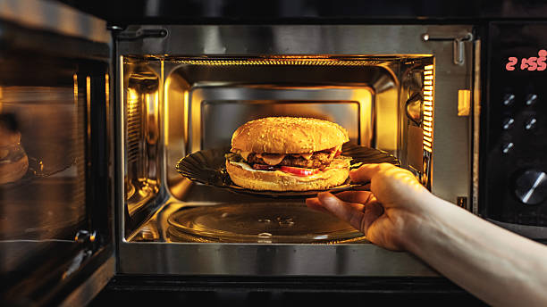 Take food from microwave. Burger on plate