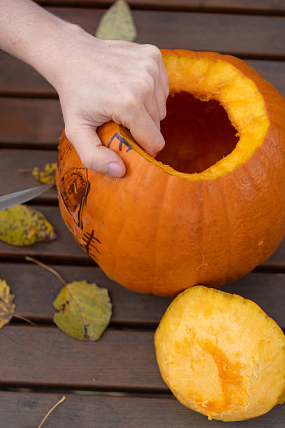 istock Creating a jack-o'-lantern with a fresh pumpkin for Halloween celebration 2234121681