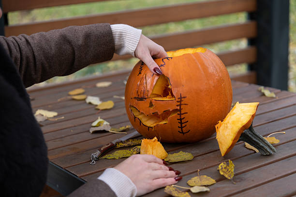 istock Carving a spooky jack-o'-lantern for Halloween celebration in the park 2234121720
