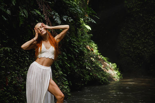 istock Woman Posing Gracefully in a Jungle by a Calm Stream 2234126827