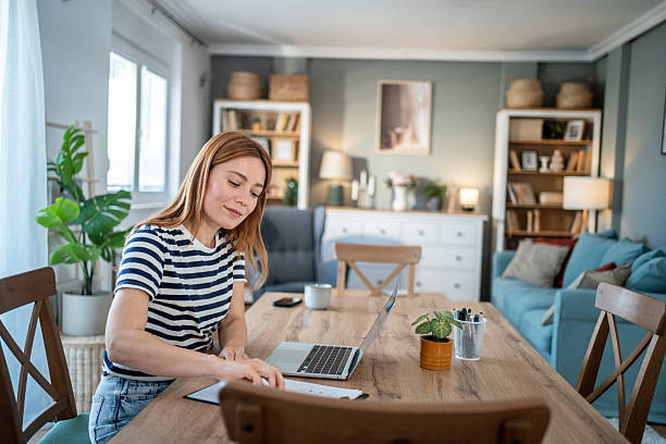 istock Young woman working from home on her laptop and taking notes 2234130923