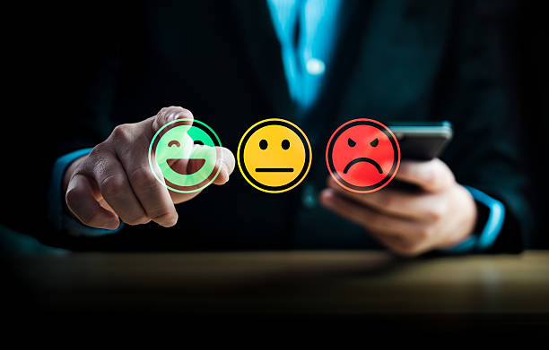 istock Customer satisfaction feedback concept showing person using mobile phone to select emotion face rating with happy, neutral, sad smiley icons representing service review and user experience evaluation 2234131429