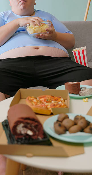 istock obese man eating junk food 2234132342