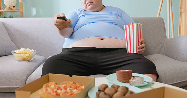 istock obese man eating junk food 2234132420