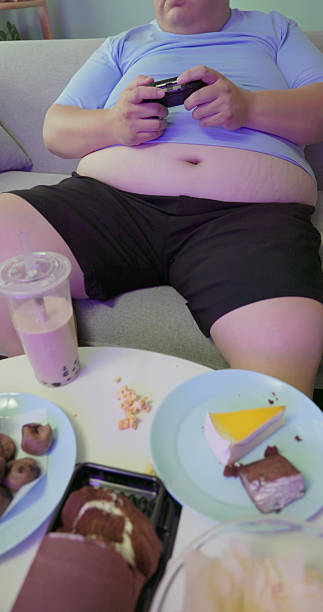 istock obese man eating junk food at home 2234132481
