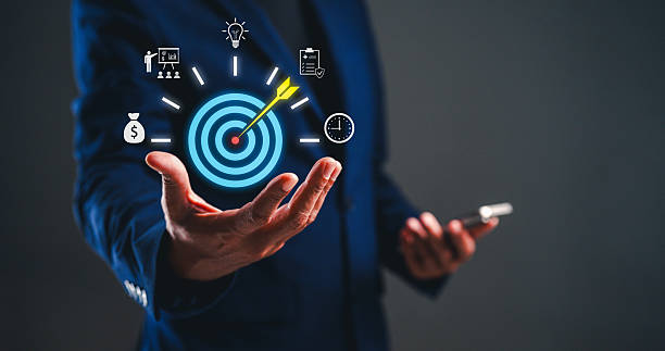 istock A businessman presents a digital target graphic, symbolizing goal achievement and focus, while holding a smartphone in a sleek, modern environment. 2234133999