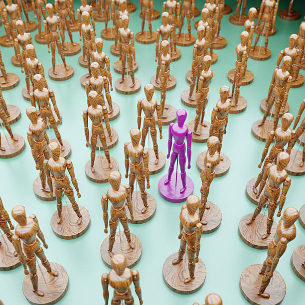 A green man stands out from the crowd. Talented and skillful suitable candidate. Initiative and active person, leader. Employee of the month. Best choice of all. Search professionals specialists