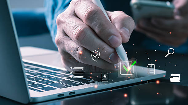 istock A professional uses a stylus on a laptop, interacting with a digital checkmark and quality icons, symbolizing compliance, quality control, audit success, and trusted business excellence. 2234149603