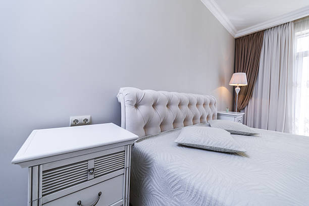 istock The headboard of a classic double bed with a curved backrest. Gray blanket with vegetable embossing. Two square pillows. 2234152418