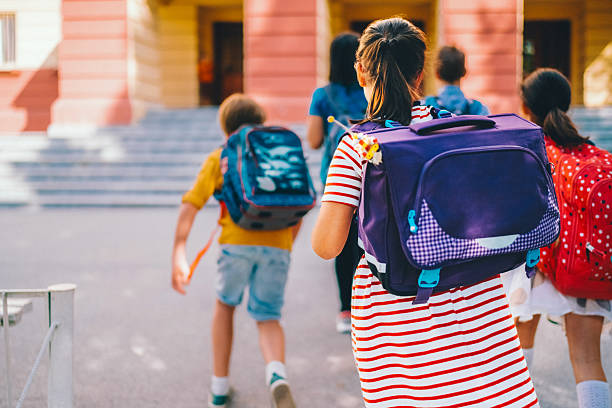 istock Group of elementary school children entering school building 2234153408