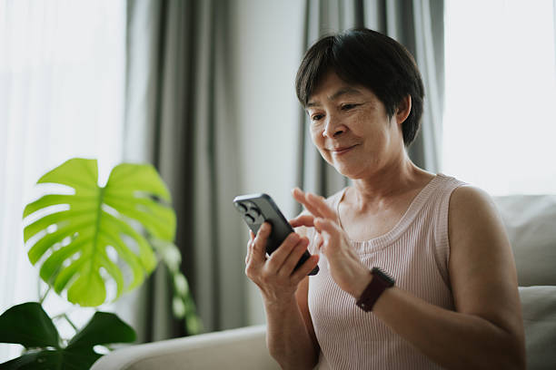 istock Mature woman using smartphone at home. 2234153934
