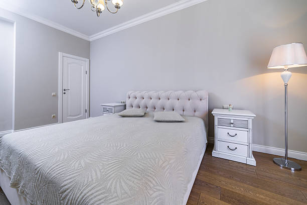 istock The headboard of a classic double bed with a curved backrest. Gray blanket with vegetable embossing. Two square pillows. 2234154173