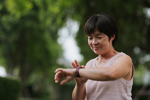 istock Mature woman using smartwatch at park. 2234154442