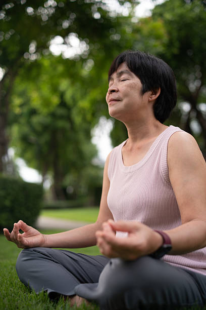 Mature woman tracking mindfulness session outdoors.