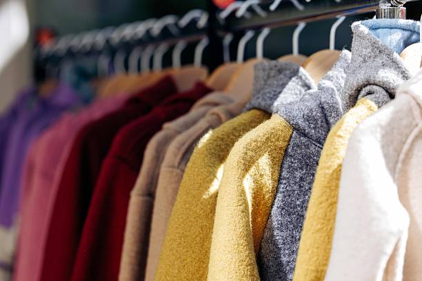 istock Colorful array of cozy sweaters hanging on a rack in sunlight 2234156131