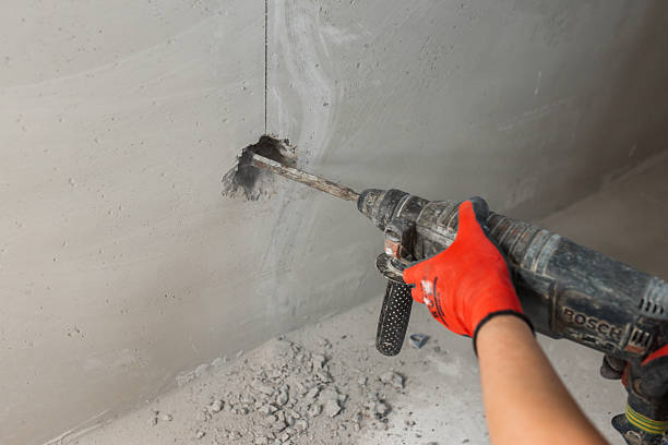 istock Closeup of worker hand with hammer drill while drilling wall 2234157105