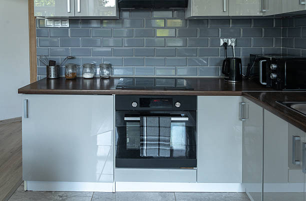 Minimalist kitchen corner with white cabinets and dark countertop, clean modern interior
