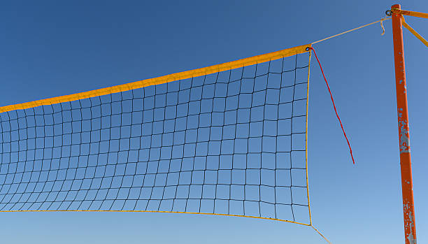 istock A bright blue sky serves as the backdrop for a volleyball net positioned at a beach, ready for play on a sunny day 2234172761