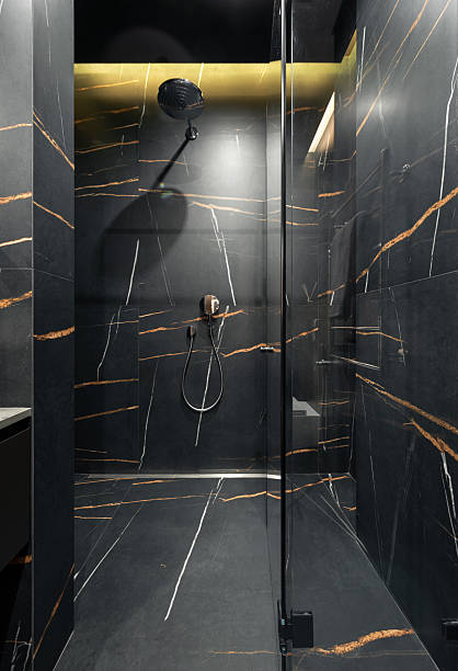 istock Empty shower room with dark grey stone tiles with orange veins. 2234174805