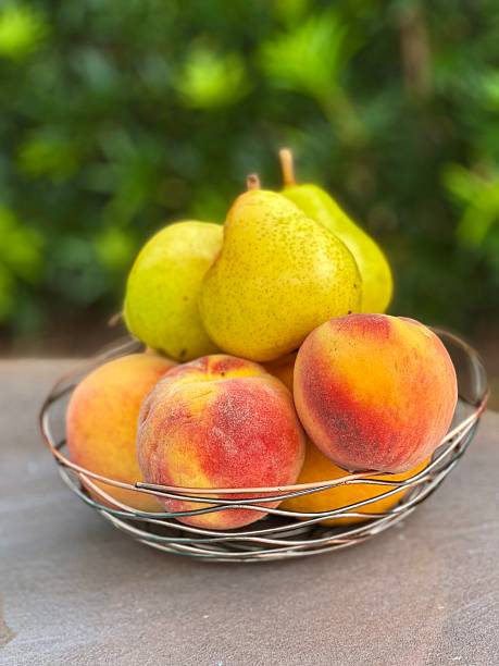 Pears, peaches and oranges in a fruit bowl