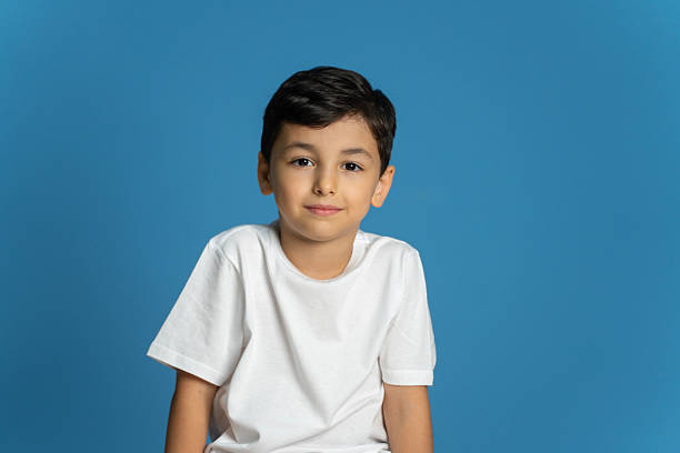 istock Cute little boy smiling portrait , Studio shot, blue wall background 2234177086