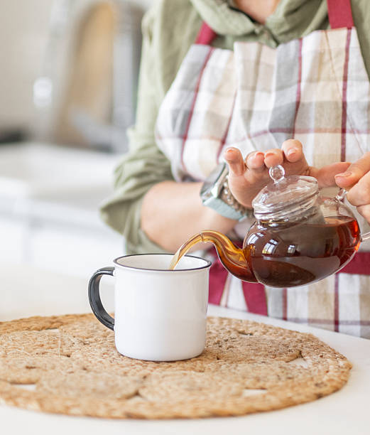 istock Woman Pouring Tea Into Mug 2234179980