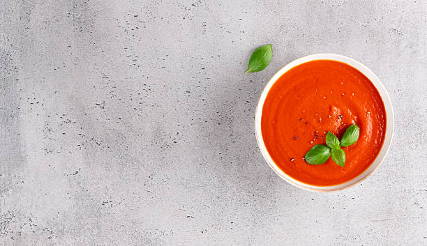 istock Bowl of aromatic tomato soup with basil on grey background. Top view. Copy space. 2234180489