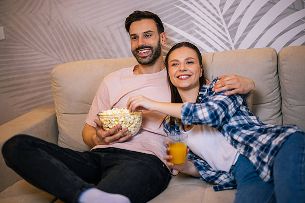 istock Happy couple hugging and watching TV at home 2234184205