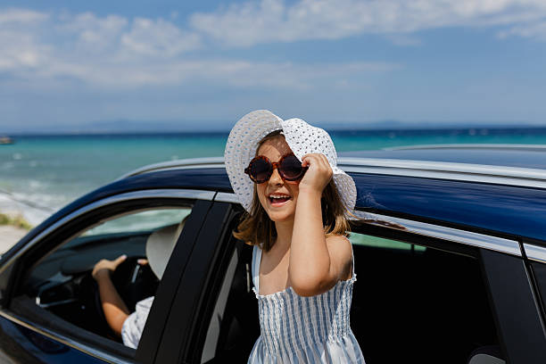 istock Cheerful girl enjoying sunny beach day while peeking from the car window 2234184548