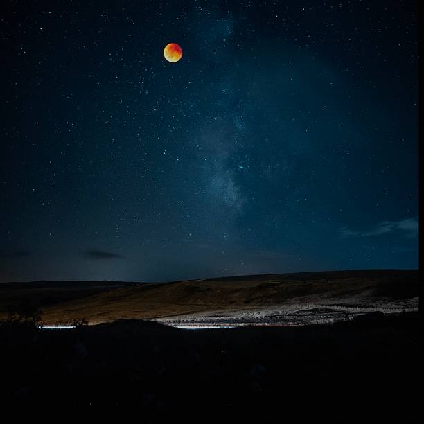 istock Blood moon eclipse and the Milky Way galaxy. Blood Moon Lunar Eclipse Over Starry Landscape 2234189415