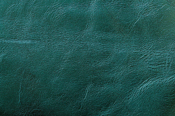 Textured teal leather surface with natural creases and subtle shine for stylish backgrounds. Concept of luxury texture, rich Transformative Teal color, bold material