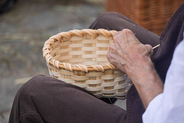 Hands of an artisan crafting a wicker basket at traditional festival in Galicia, Spain