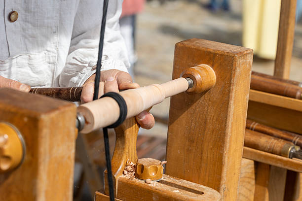 istock Carpenter turning wood with traditional foot powered lathe 2234197804