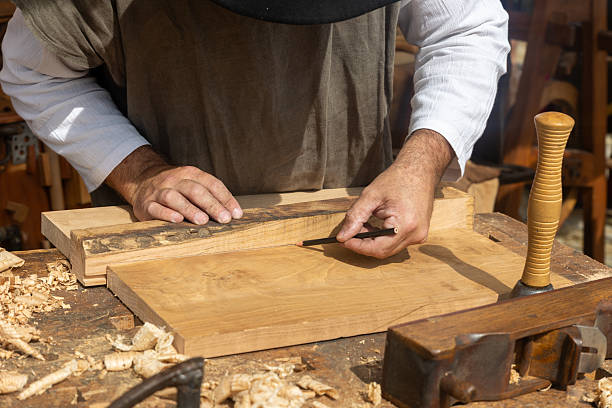 istock Carpenter marking wood plank with pencil in workshop 2234197840