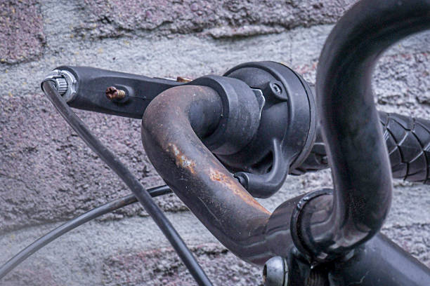 Close-up of a bell attached to a vintage bicycle handlebar.