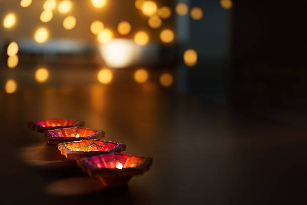 Diwali candle lighting with bokeh background for festive celebration