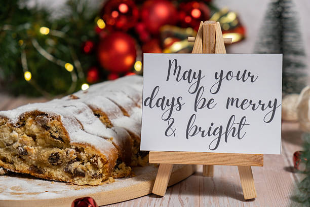 istock Note with saying MAY YOUR DAYS BE MERRY AND BRIGHT congratulations. Traditional German Christmas stollen cake in background of handmade festive decor. Winter holiday treats. Vegan baking recipe 2234222666