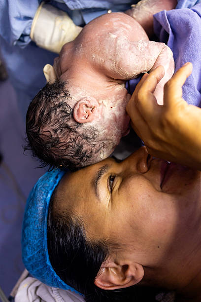 istock Mother hugging her newborn baby for the first time during a cesarean section 2234225601