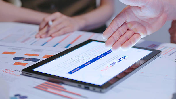 istock Close up Diverse Collaborative Business people meeting with Digital Devices computer brainstorming the financial report paperwork document analyzing data  planning strategies displays a graph  chart in a modern business technology overworked late at night 2234227899