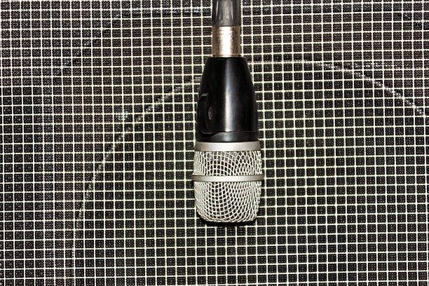 microphone dynamic for drums, standing in front of a speaker , abstract music background , professional audio