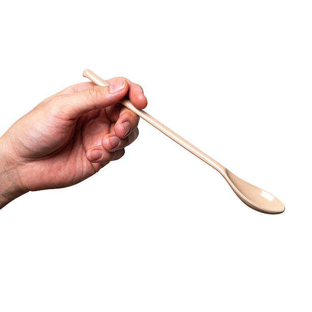 istock Male hand holding a brown plastic spoon isolated on white background. 2234229257